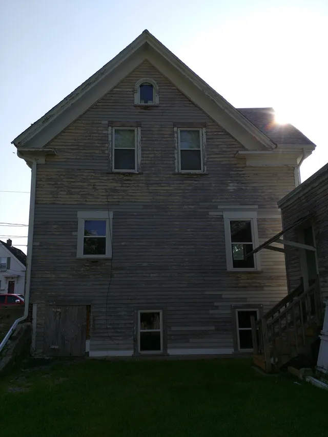 Weathered two-story home before new siding