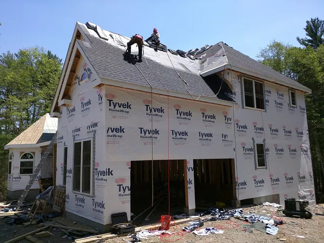 New construction home wrapped for siding with the roof going on